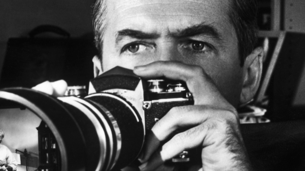 Джеймс Стюарт держит камеру в фильме Альфреда Хичкока "Заднее окно".
