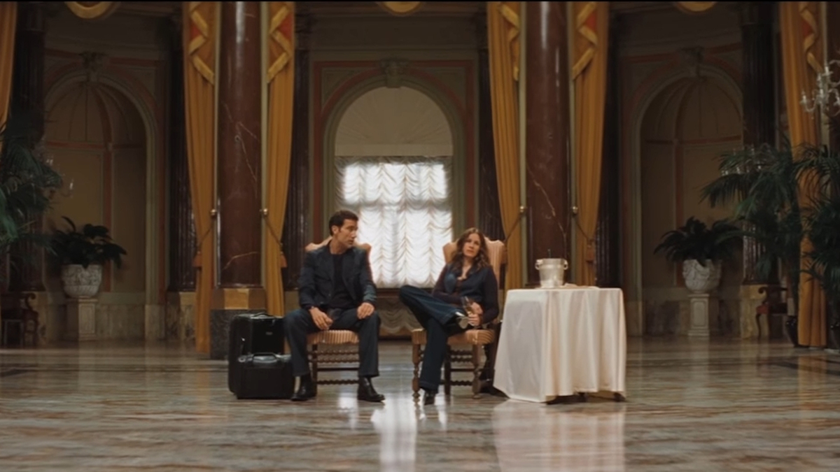 줄리아 로버츠와 클라이브 오웬이 영화 <듀플리시티>의 화려한 로비에 앉아 있다.