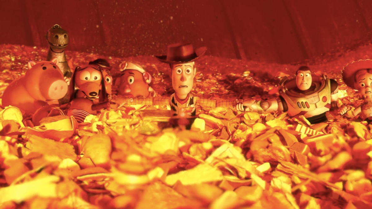 Os brinquedos de Andy aproximam-se de uma fogueira de lixo em Toy Story 3