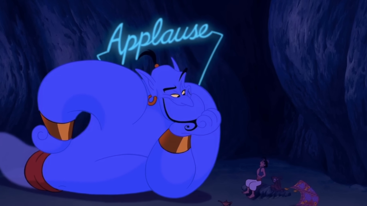 Genie odottaa suosionosoituksia luolassa elokuvassa Aladdin.