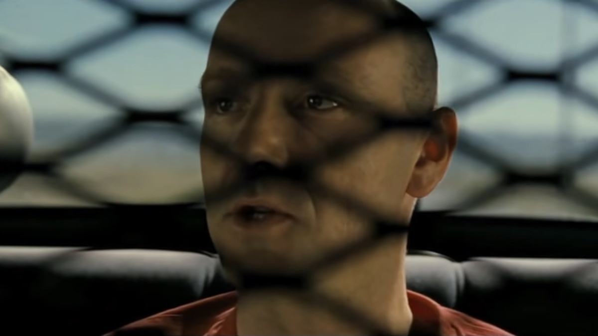 John Doe jezdí na zadním sedadle policejního auta ve filmu Sedm