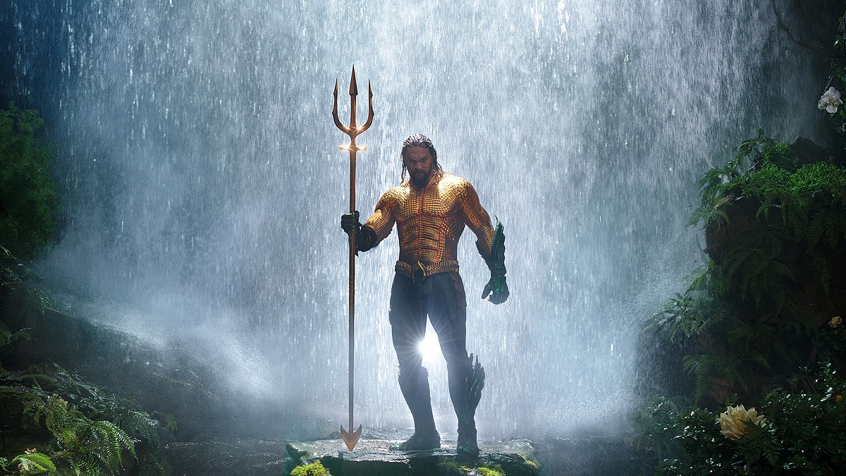 Джейсон Момоа стоит в доспехах Аквамена у водопада в фильме "Аквамен".