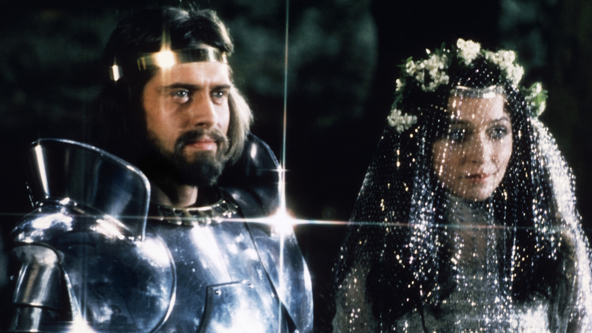 Král Artuš stojí v brnění vedle Guenevery ve filmu Exclaibur