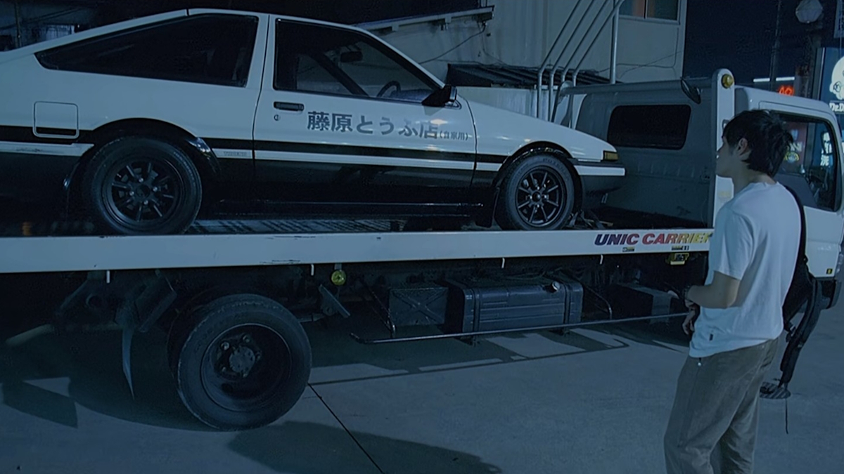 Takumi se dívá na bílo-černou Toyotu svého otce ve verzi Initial D.