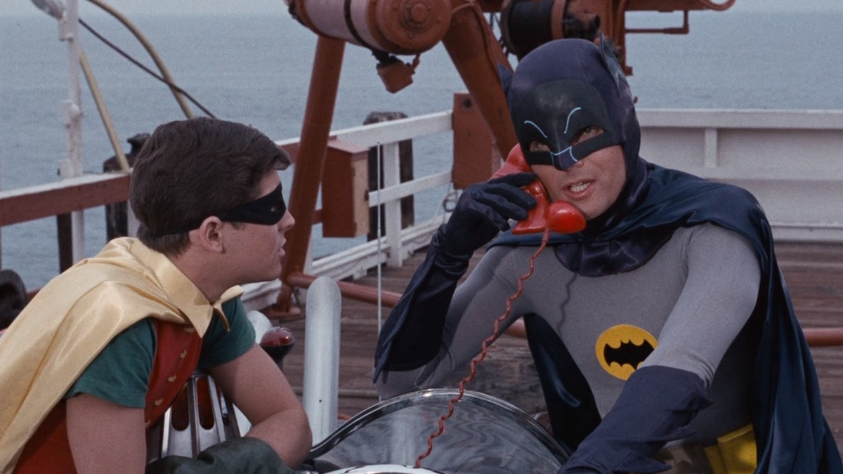 Batman e Robin usano il telefono della Batmobile sulla spiaggia