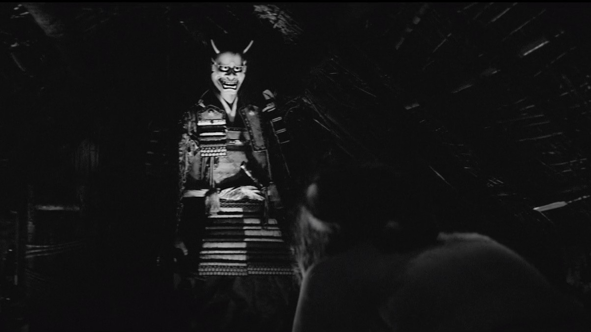 Egy ijesztő maszkot viselő szamuráj áll egy kunyhóban az Onibaba című filmben.