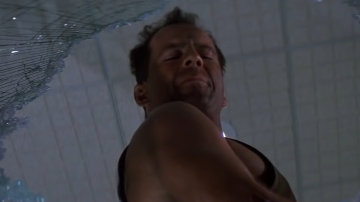 John McClane hurle par-dessus une fenêtre brisée dans Die Hard