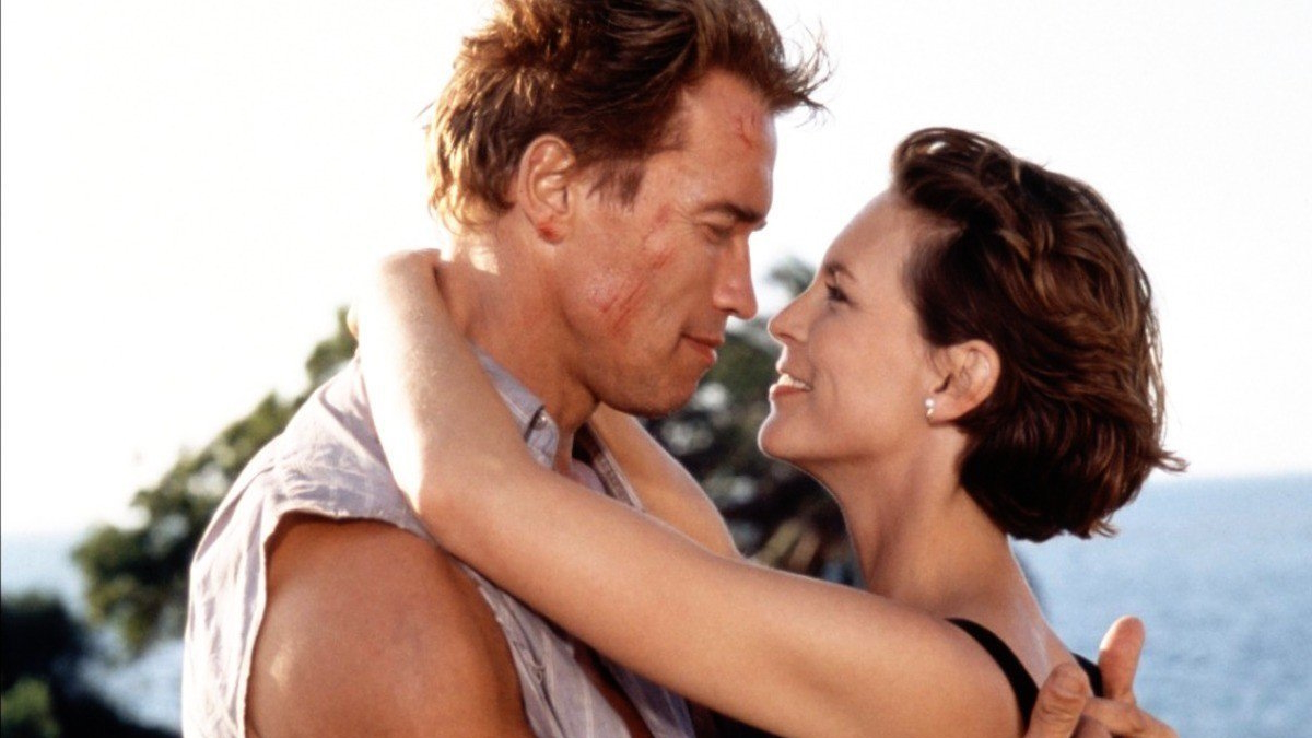 Arnold Schwarzenegger e Jamie Lee Curtis abraçam-se ao sol em True Lies