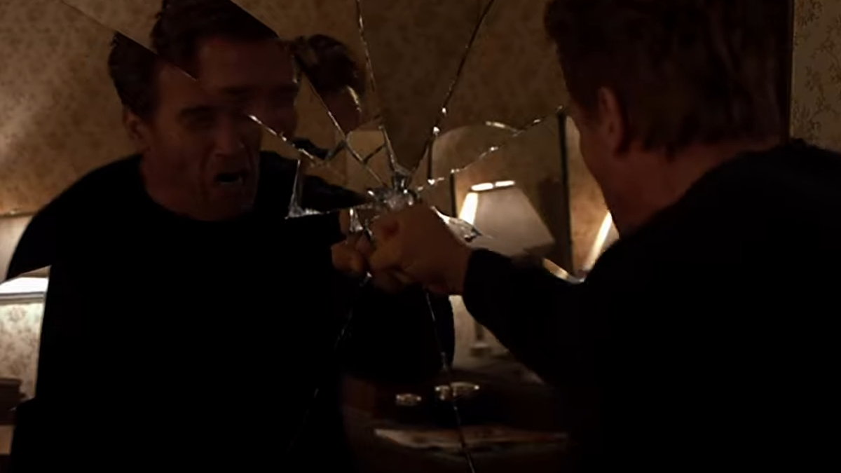 Arnold Schwarzenegger prende a pugni uno specchio in End of Days