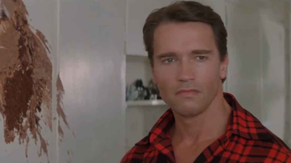 Arnold Schwarzenegger está numa cozinha arruinada por um bolo em Raw Deal