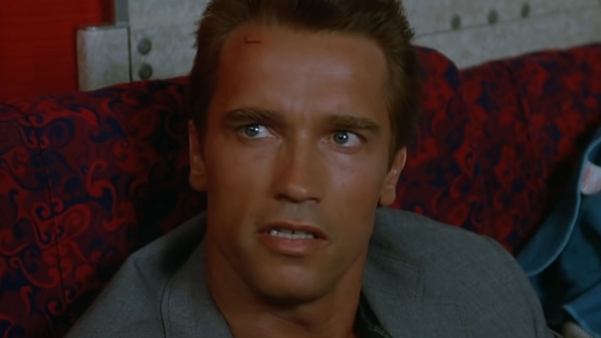 Arnold Schwarzenegger seduto su un aereo in Commando