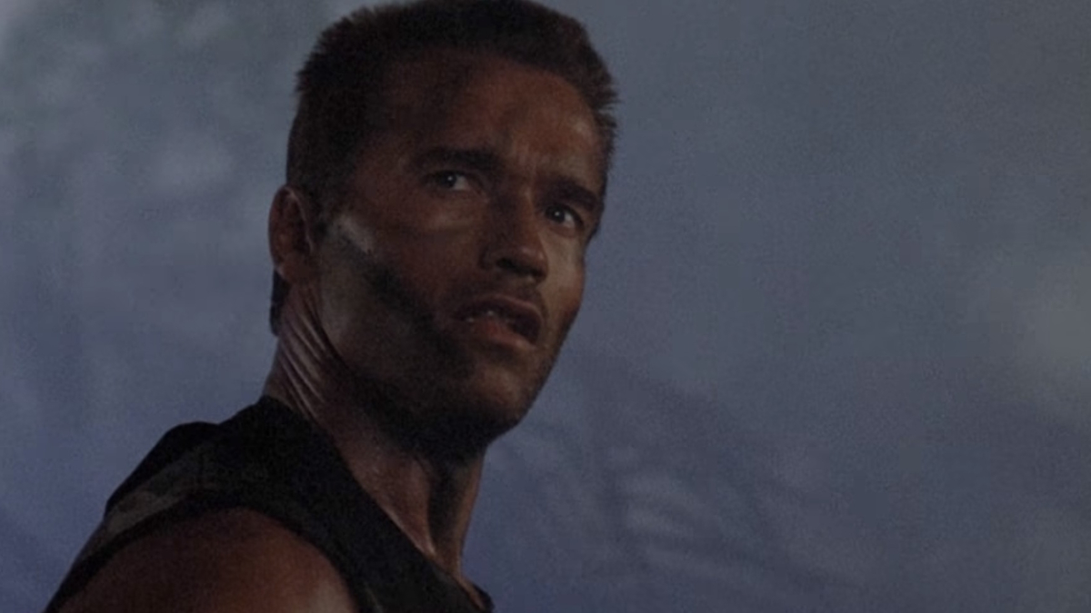 Arnold Schwarzenegger de pé numa selva enevoada em Predador