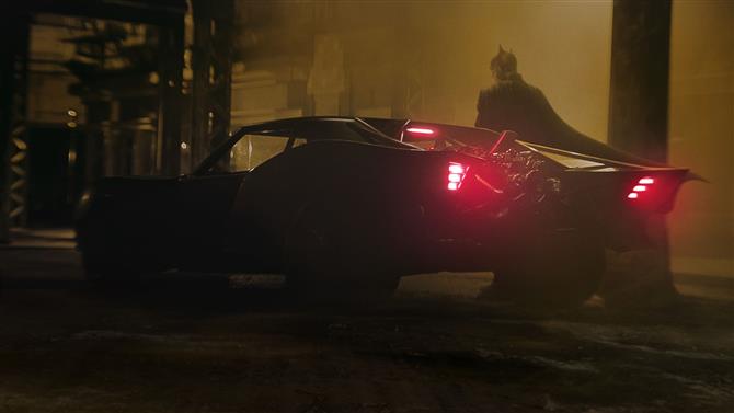 "バットマンはバットモービルの隣に立っています"