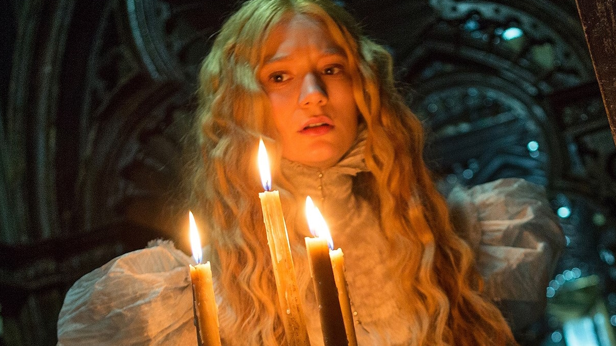 Mia Wasikowska pitelee kynttilöitä goottilaisessa kartanossa elokuvassa Crimson Peak.