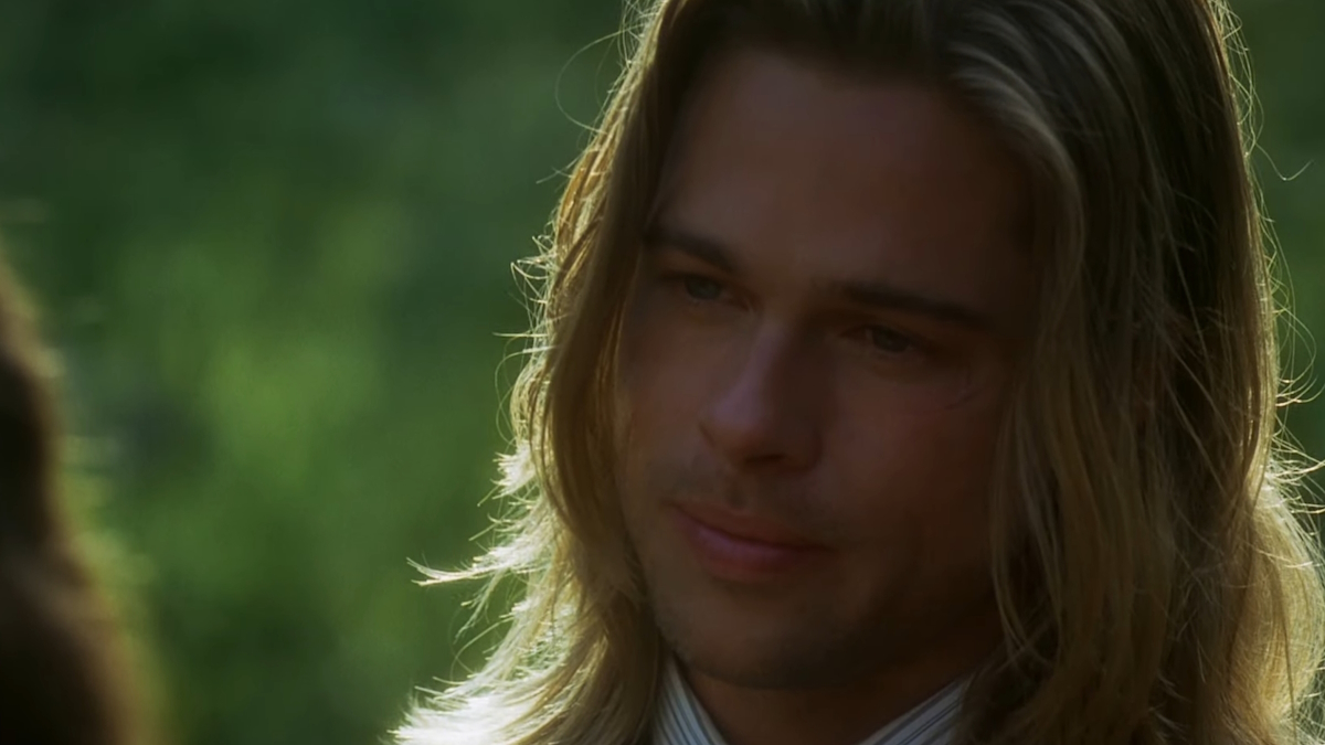 Brad Pitt, w długich blond włosach, stoi pod słońcem w Legends of the Fall