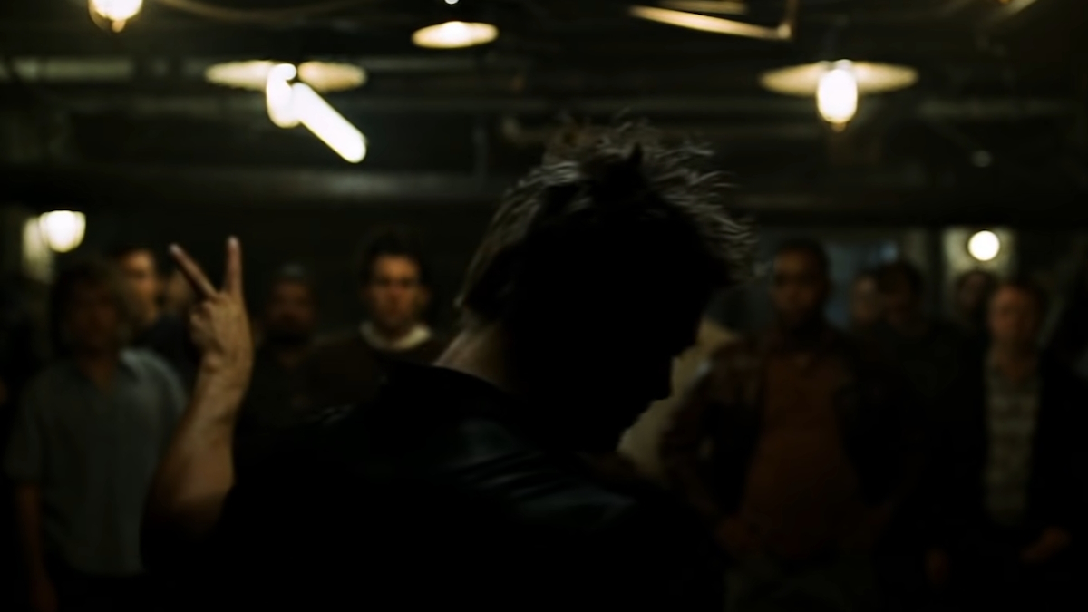 Brad Pitt v roli Tylera Durdena předává mužům pravidla Klubu rváčů v ponurém sklepě ve filmu Klub rváčů