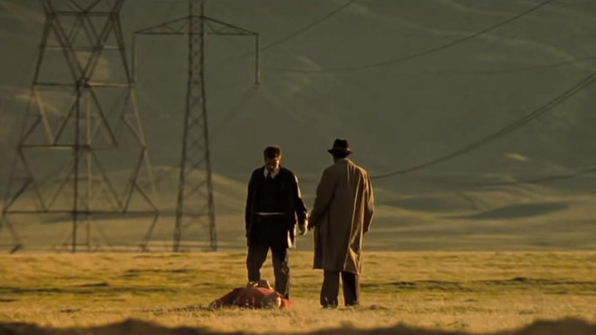 Брэд Питт и Морган Фримен стоят в пустыне в конце фильма "Семь".