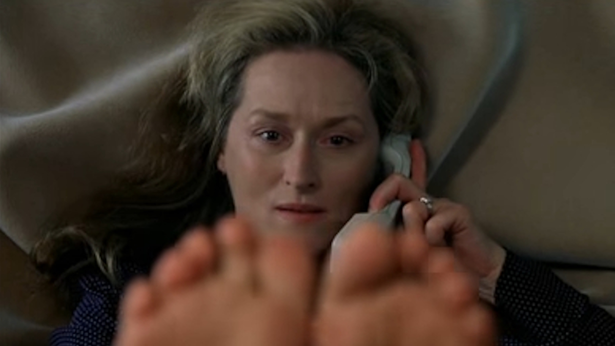 Meryl Streep fala ao telefone com os dedos dos pés a preencher a parte inferior do enquadramento