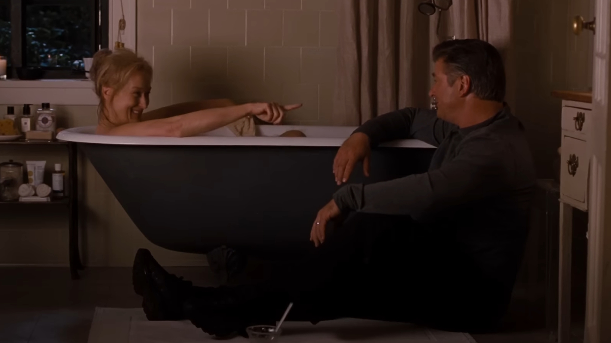Meryl Streep in una vasca da bagno parla con suo marito, seduto al di fuori di essa nel loro bagno, in È complicato