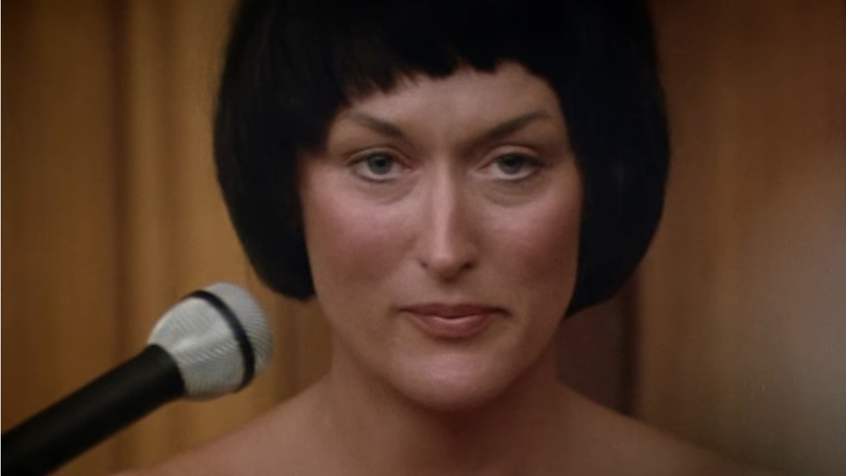 Meryl Streep, con i capelli neri corti, siede in tribunale nel film Un grido nel buio