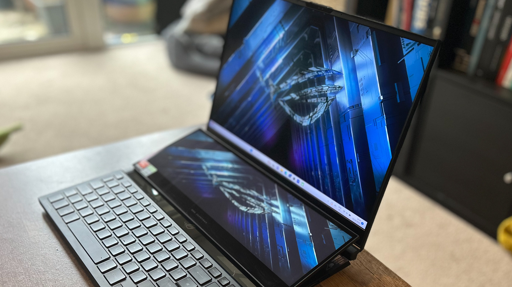 Asus ROG Zephyrus Duo 16 Gaming-Laptop mit geöffnetem Bildschirm auf einem Holztisch