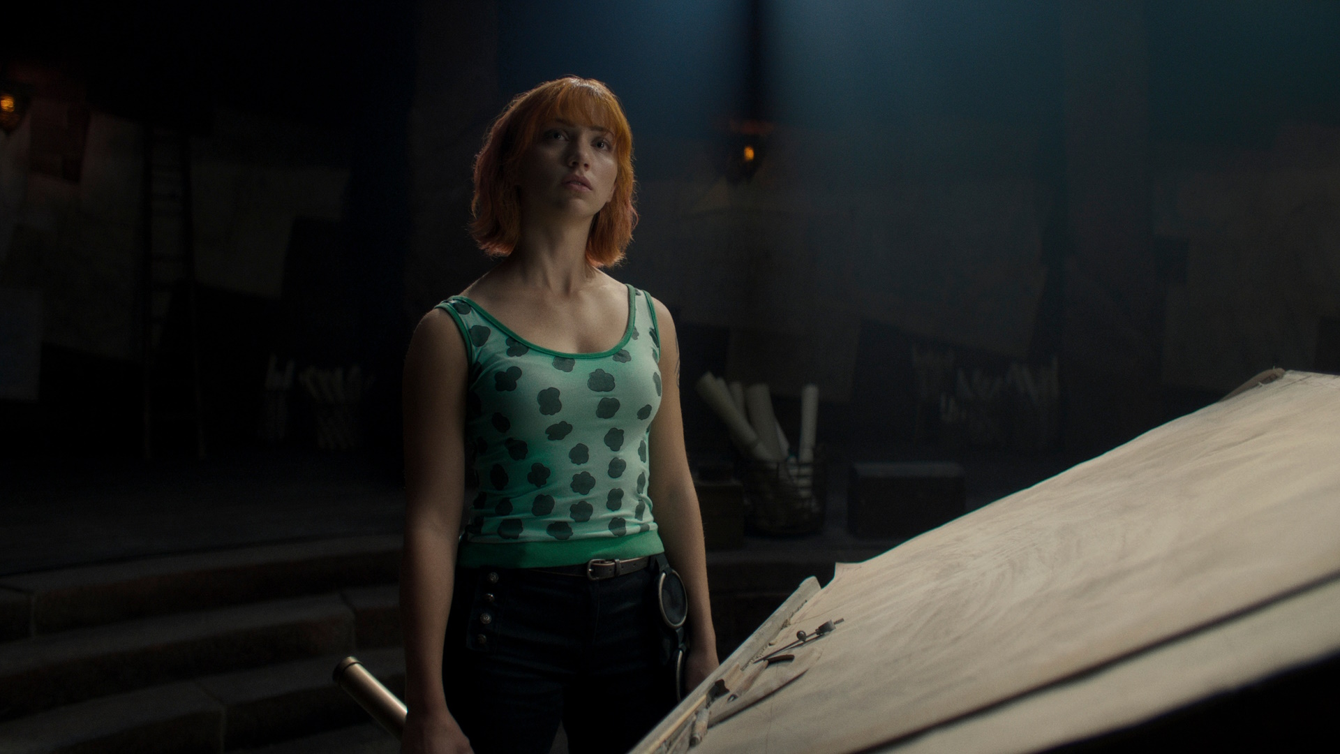 Emily Rudd som Nami står i mørket i et stillbilde fra Netflix' One Piece.