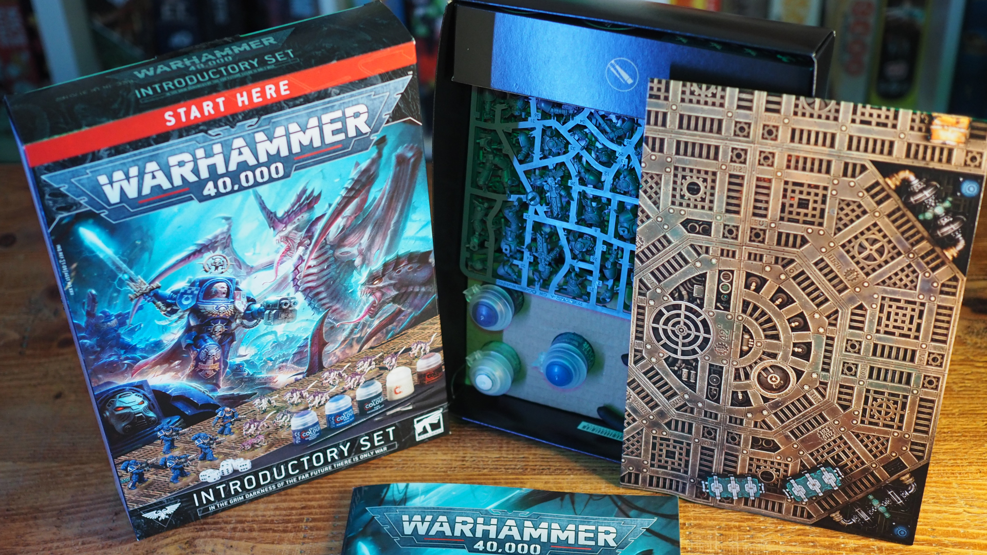 مجموعة Warhammer 40k التمهيدية والمحتويات التي تقف على طاولة خشبية