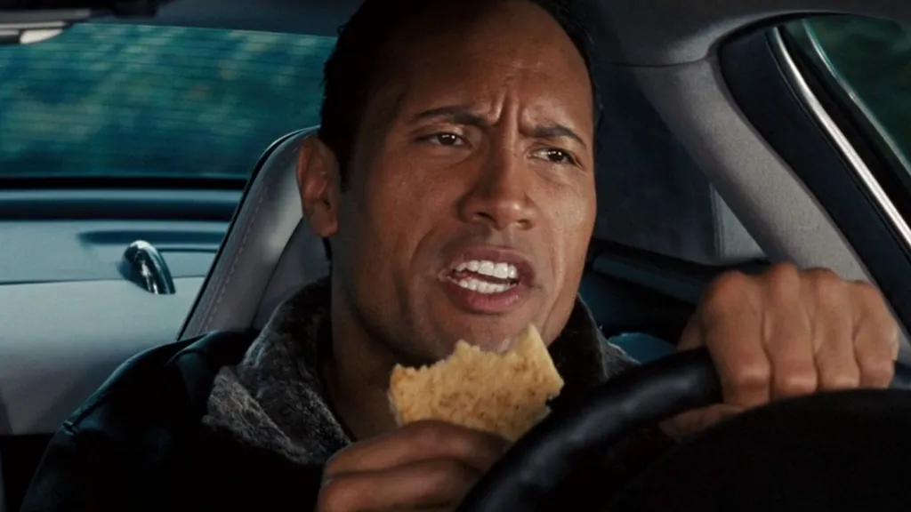 Dwayne Johnson sütit eszik, miközben egy puccos autót vezet a The Game Planben