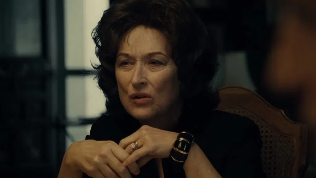 Meryl Streep rövid fekete hajjal ül a családi vacsoraasztalnál az August: Osage megye című filmben.