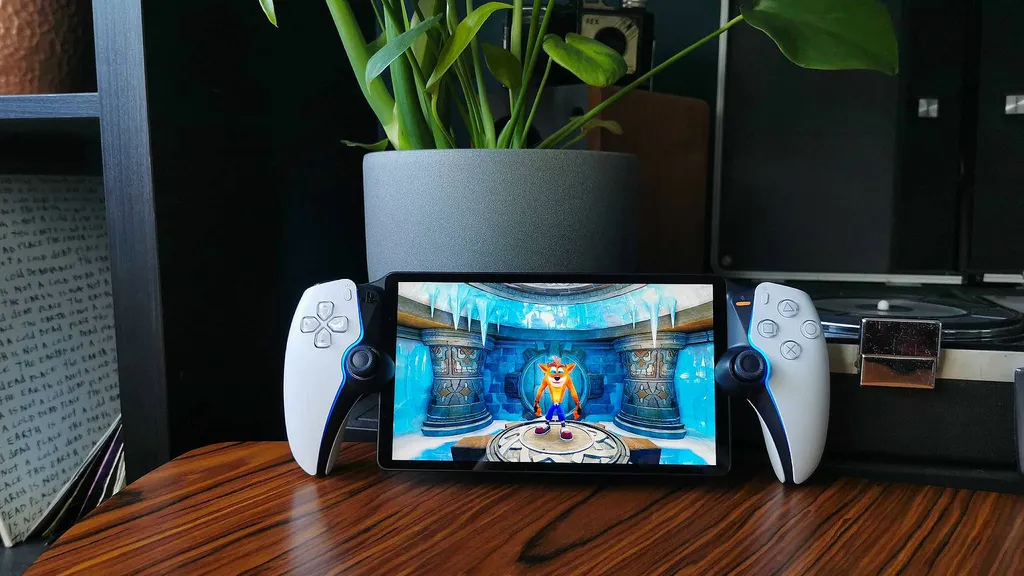 PlayStation Portal a fából készült asztalon a növény mellett
