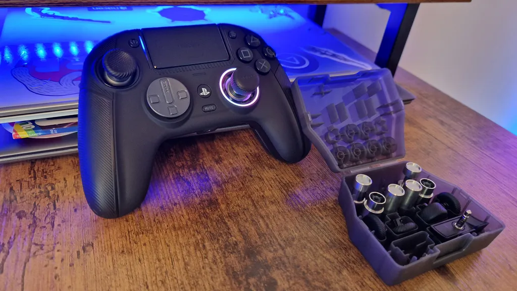 Nacon Revolution 5 Pro mit eingeschaltetem RGB-Lichtring und geöffneter Zubehörbox daneben